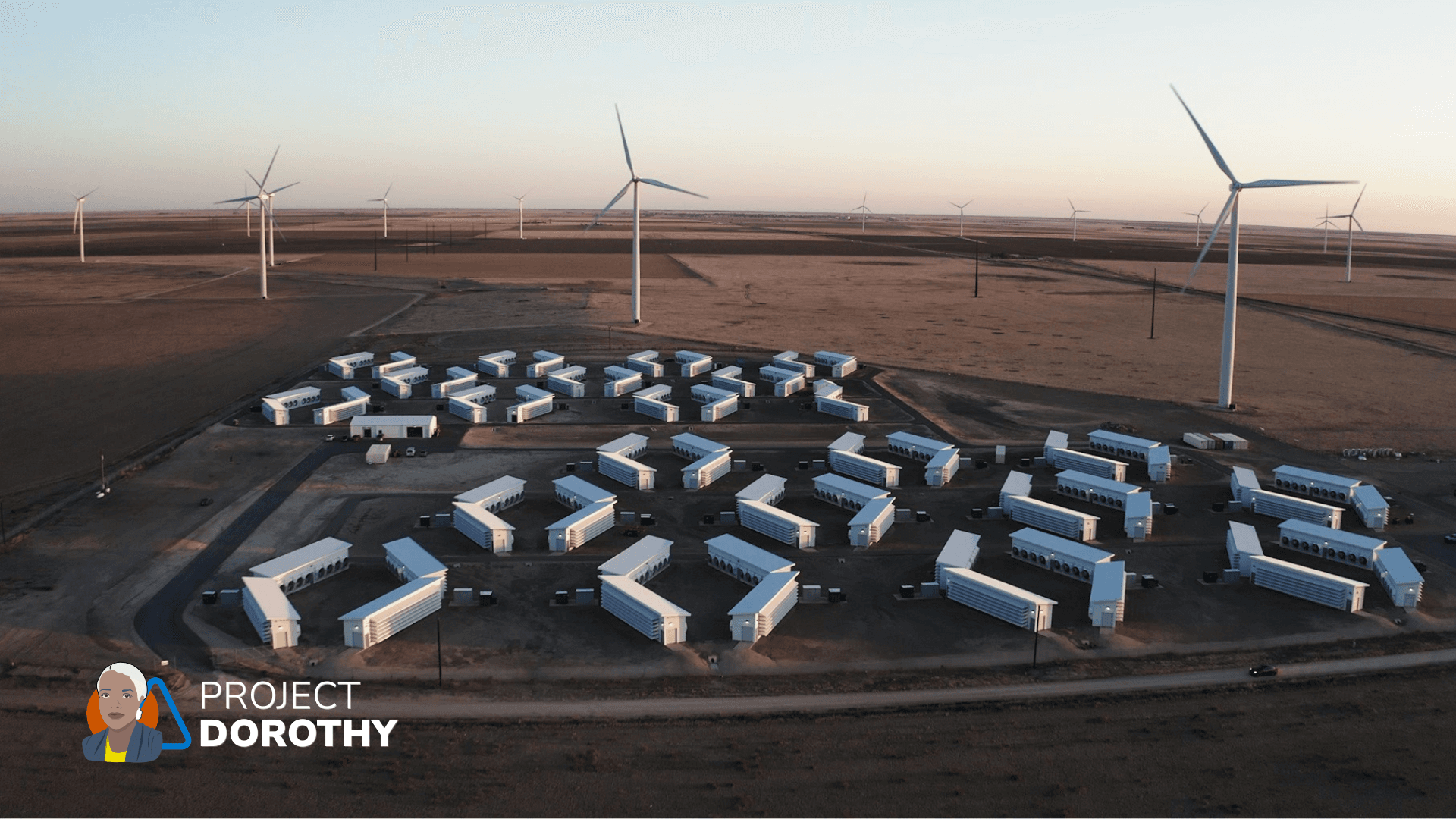 Aerial view of white modular data center buildings among wind turbines at Soluna's Project Dorothy campus in Texas