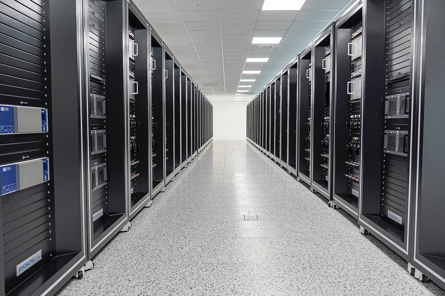 Rows of black equipment cabinets with Hyosung nameplates in a bright hall, from Hyosung Heavy Industries' HVDC newsroom release