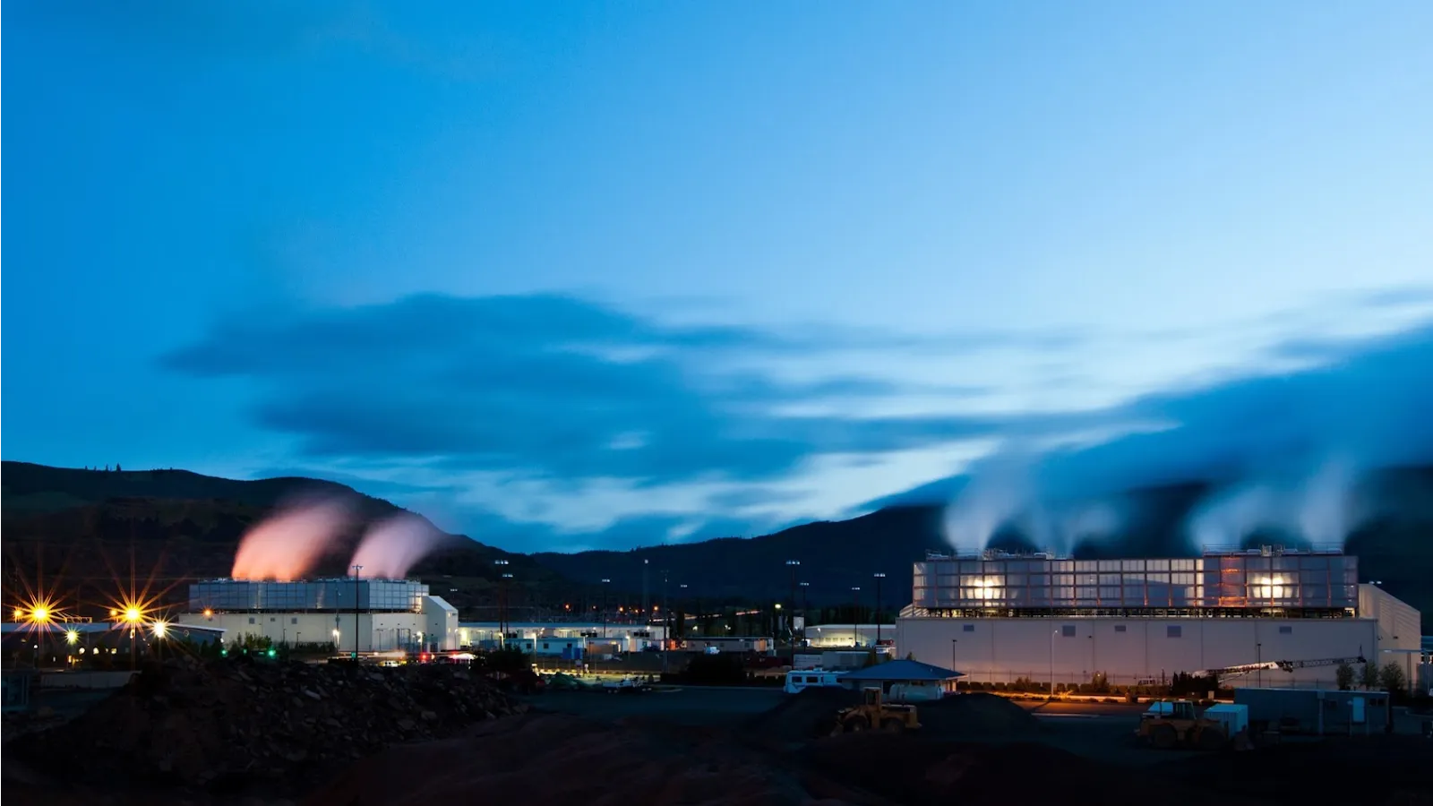Google data center in The Dalles, Oregon, at dusk with cooling-plant steam, shown as a Google facility file photo