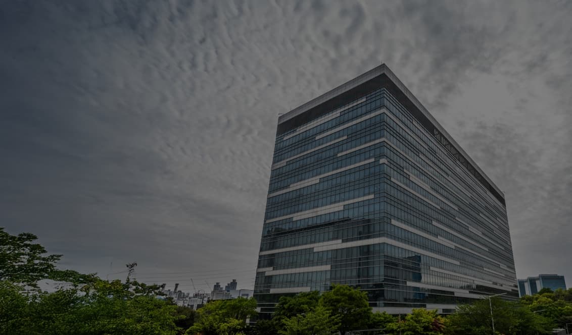 Glass office tower of Samsung Semiconductor's regional headquarters in Korea under a cloudy sky