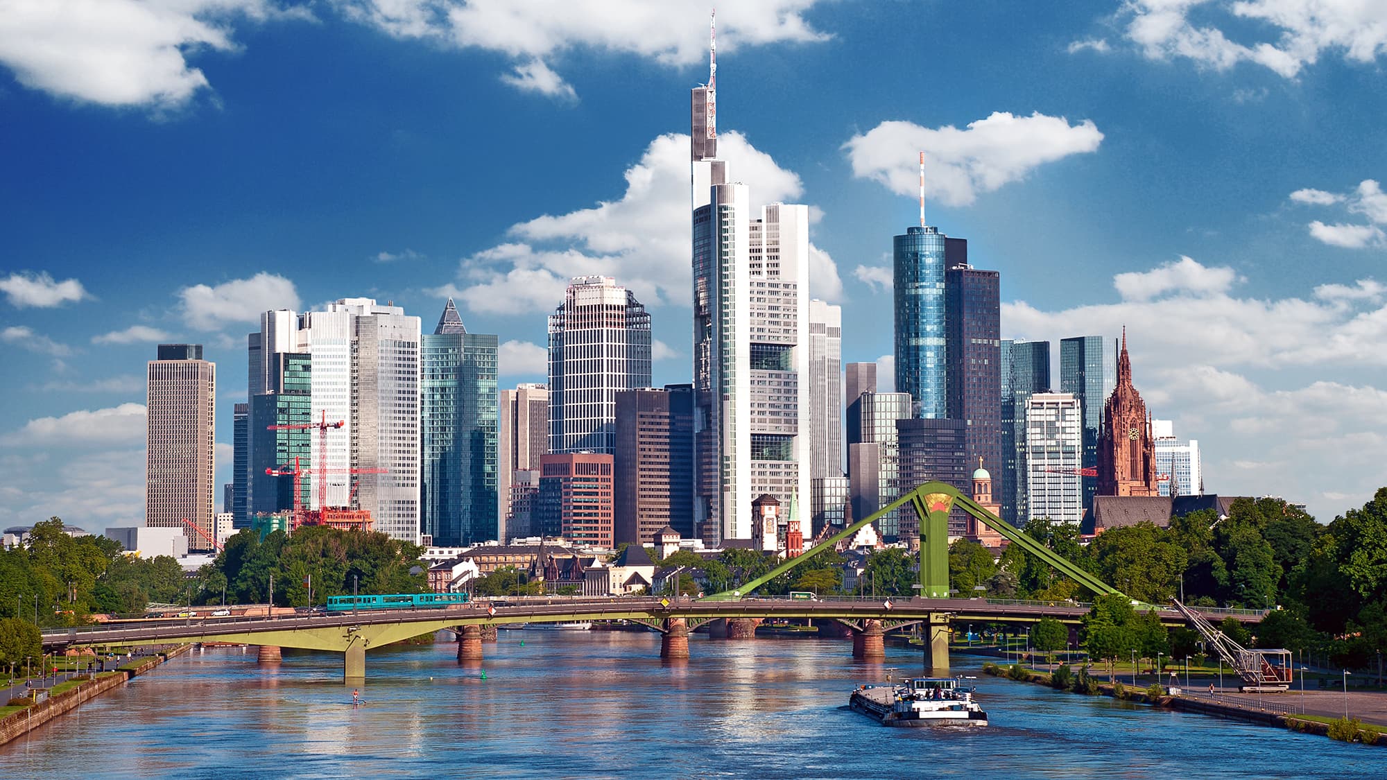 Skyline of Frankfurt am Main with high-rise towers beside the river Main on a sunny day