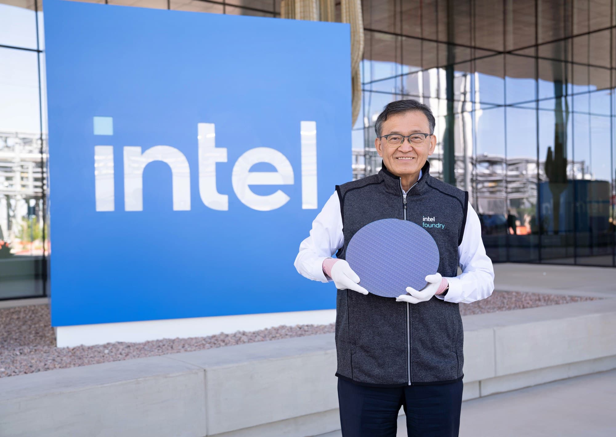 Intel CEO Lip-Bu Tan holds a Panther Lake wafer in front of an Intel sign at the Ocotillo campus in Chandler, Arizona