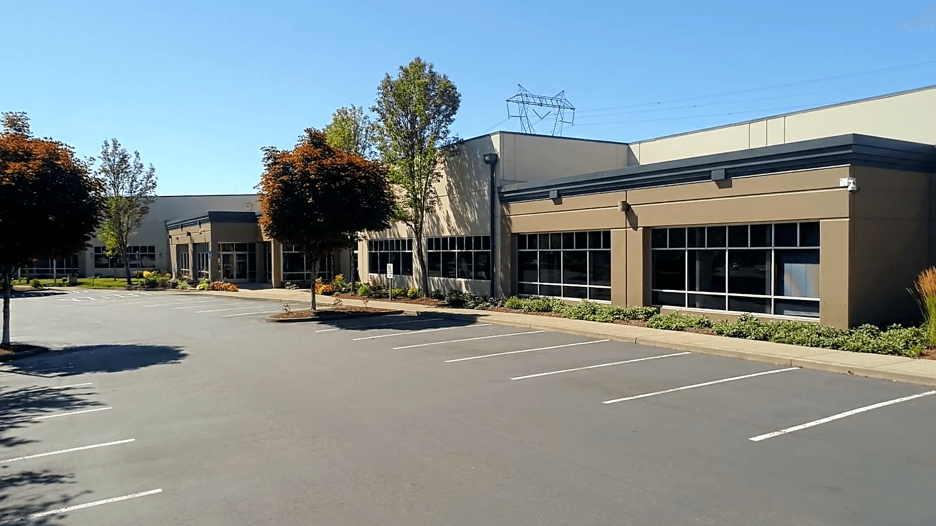 Exterior of US Signal's data center building in Hillsboro, Oregon, with a parking lot in front and a power line tower behind