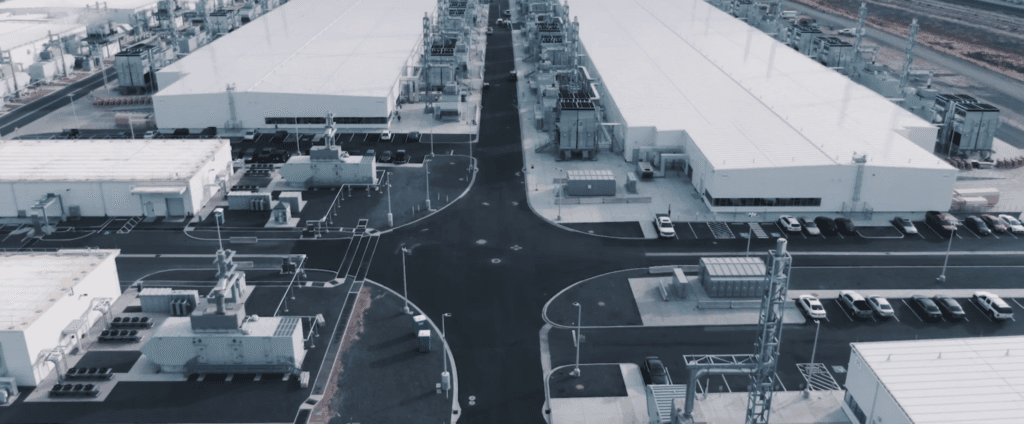 Aerial view of a Microsoft data center campus with large white halls, power equipment and a car park