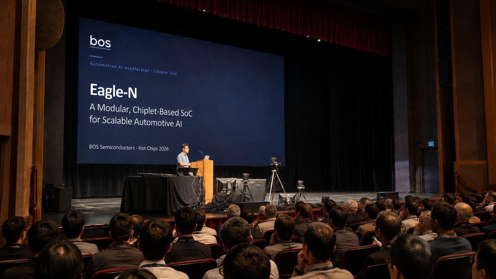 BOS presenter at a podium beside a screen reading Eagle-N and BOS Semiconductors Hot Chips 2026, with an audience in front