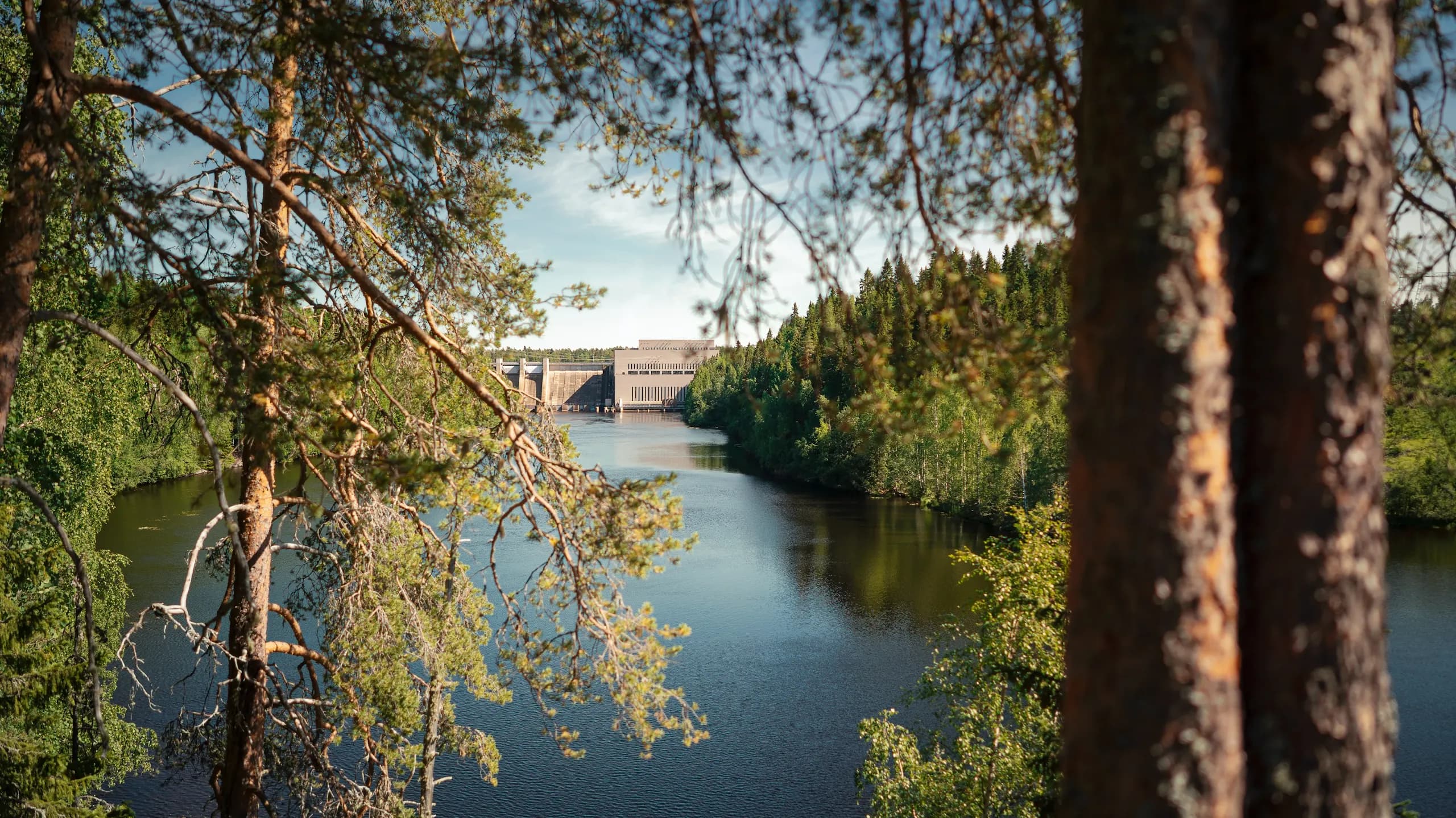 River and hydropower dam seen through pine trees near Muhos, Finland, on Google's Muhos data center location page