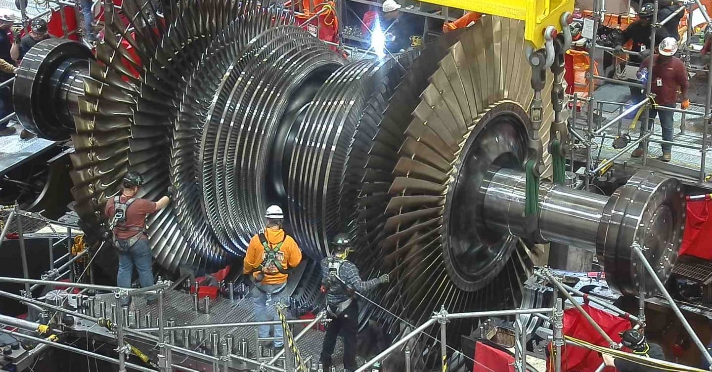 Workers beside a nuclear plant steam turbine rotor during maintenance, image from Constellation's release on the DOE loan commitment for nuclear uprates