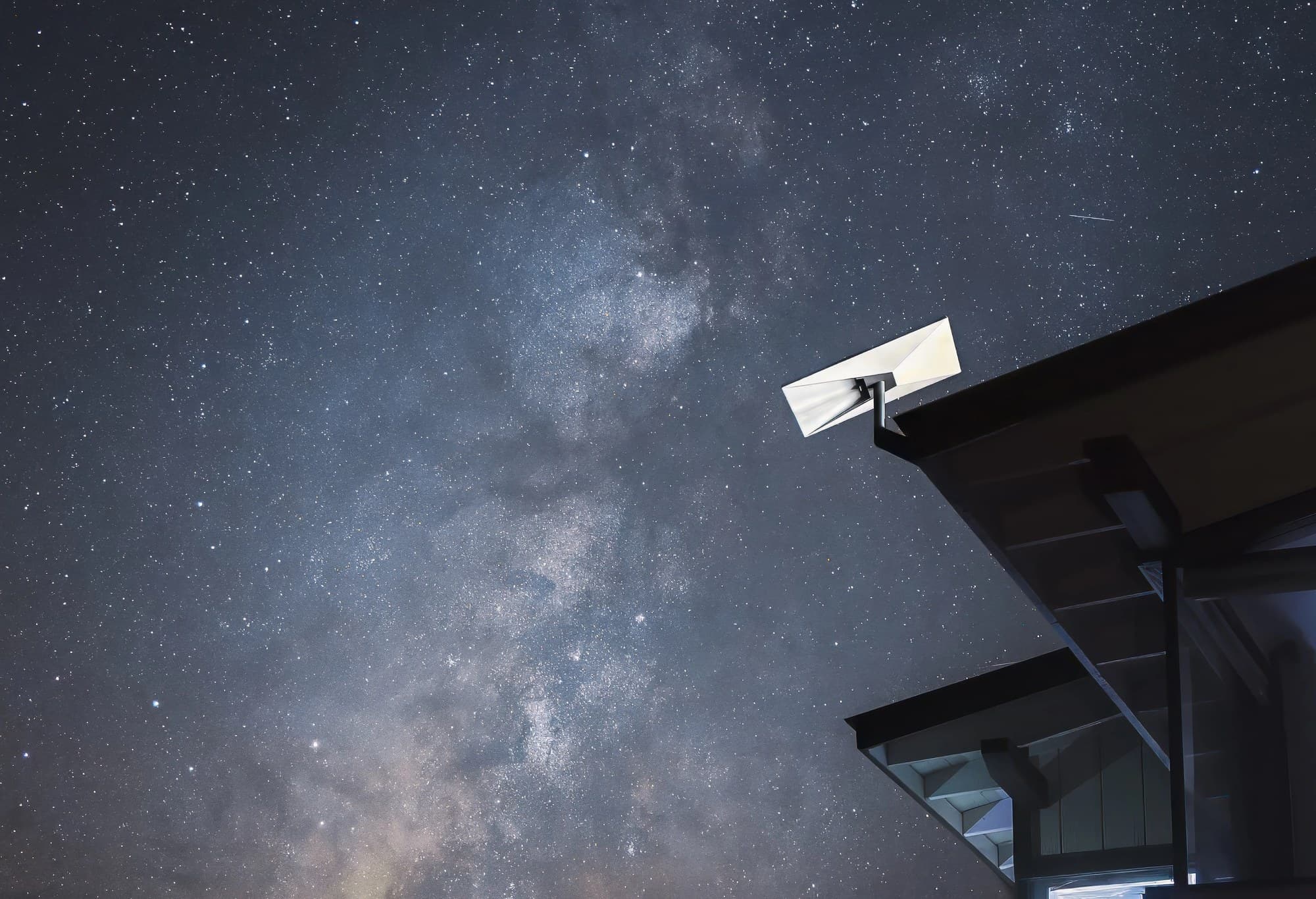 Starlink dish on a roof edge under a night sky and the Milky Way, from SpaceX's Starlink site