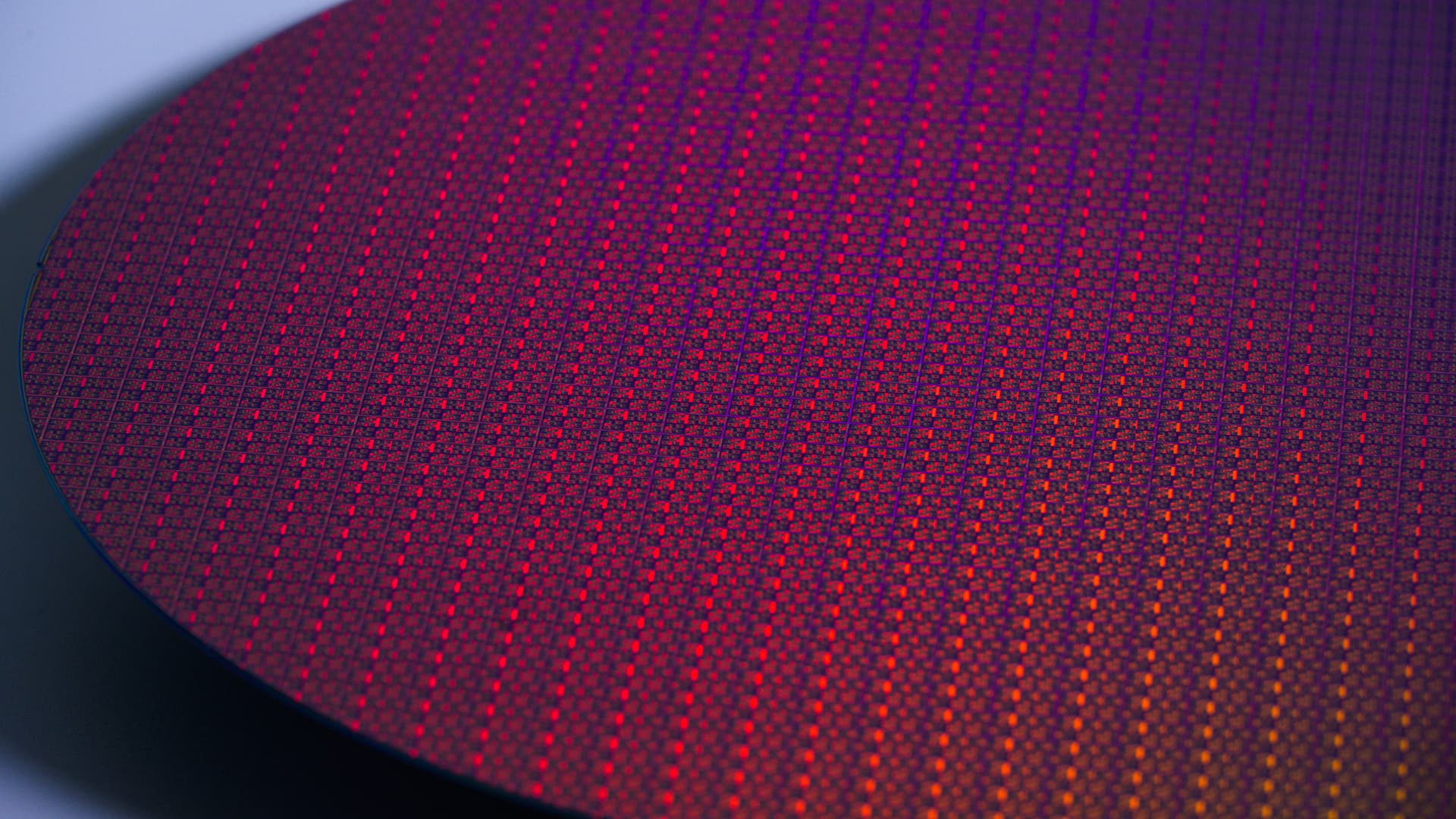 Close-up of a processed Intel 18A silicon wafer with rows of chip dies reflecting red and purple light